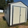 8x16 Scratch and Dent Ridgeline Shed, cream metal with black roof and double doors, on grass under blue sky; available now.